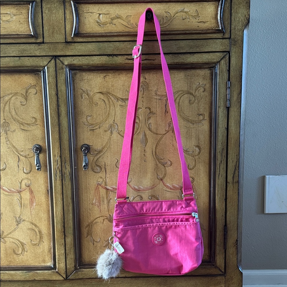 NWT Kipling Emmylou fuchsia crossbody adjustable bag with bag charm included.